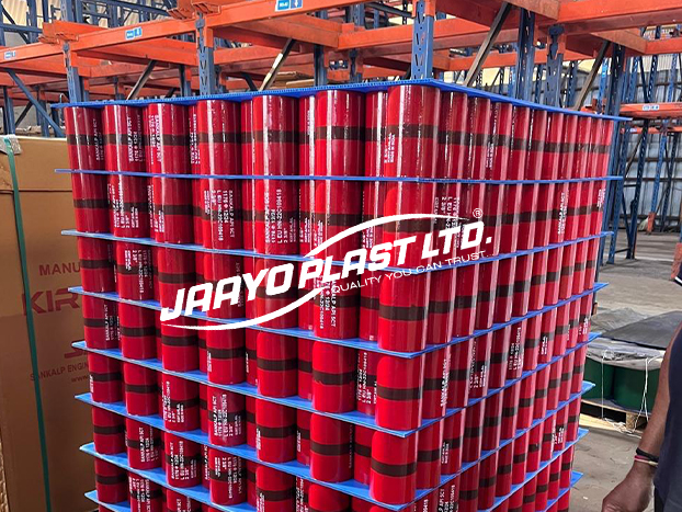 Blue PP layer pads separating tiers of red rolls on a pallet