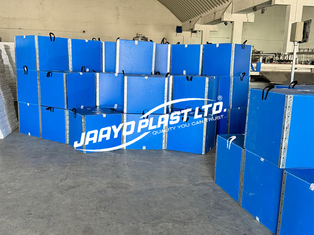Stacked blue returnable PP boxes with strap handles at the plant